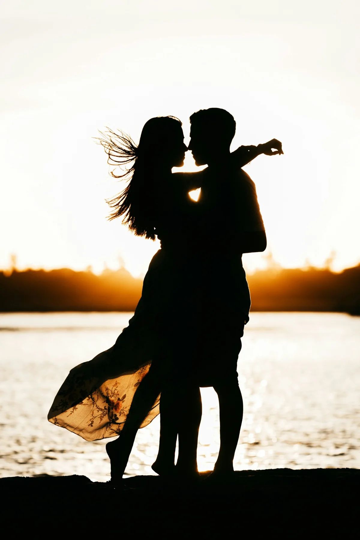 Couple silhouette together at sunset